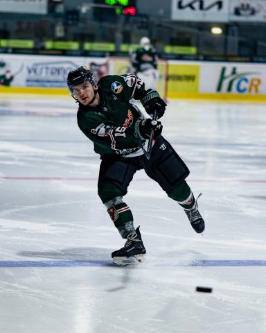 Eishockeyspieler schießt den Puck auf dem Eis während des Trainings.