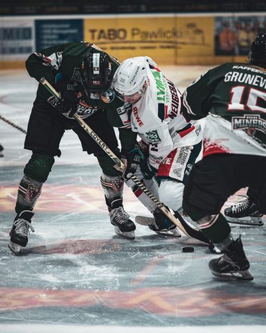 Zwei Eishockeyspieler kämpfen um den Puck auf dem Eis.