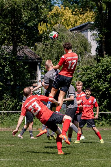 Zwei Fußballspieler springen hoch, um den Ball im Spiel zu erreichen.
