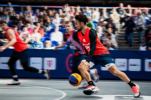 Ein Basketballspieler dribbelt den Ball während eines Spiels im Freien.