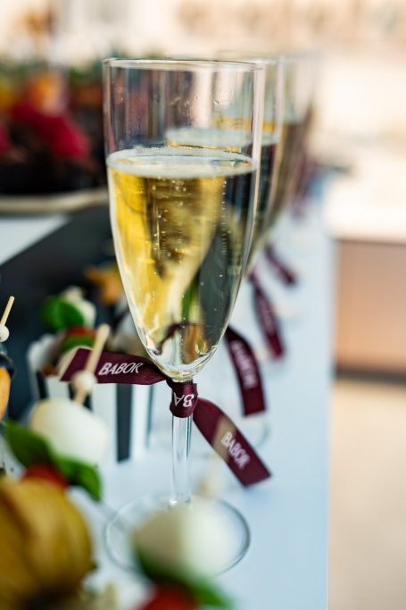 Gläser mit Sekt stehen neben festlichen Häppchen auf einem Tisch.