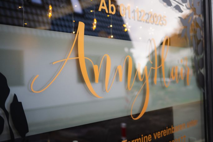 Elegante goldene Schrift des Namens "AnnyLian" auf einer gläsernen Oberfläche.