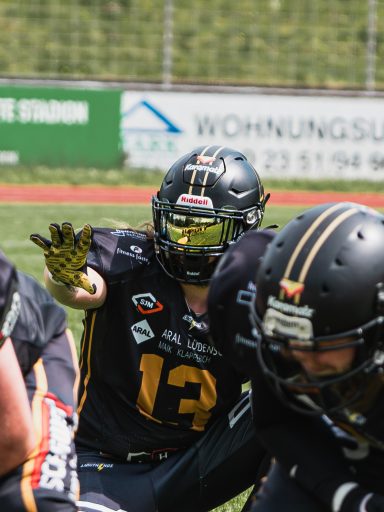 American Footballspieler in schwarzer Ausrüstung, bereit für den Spielzug.