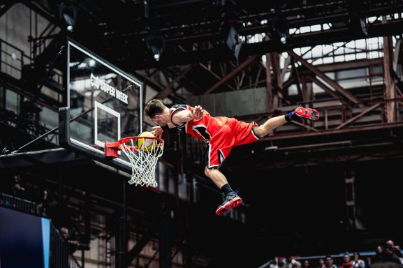 Ein Basketballspieler springt während eines Dunkings über das Netz.
