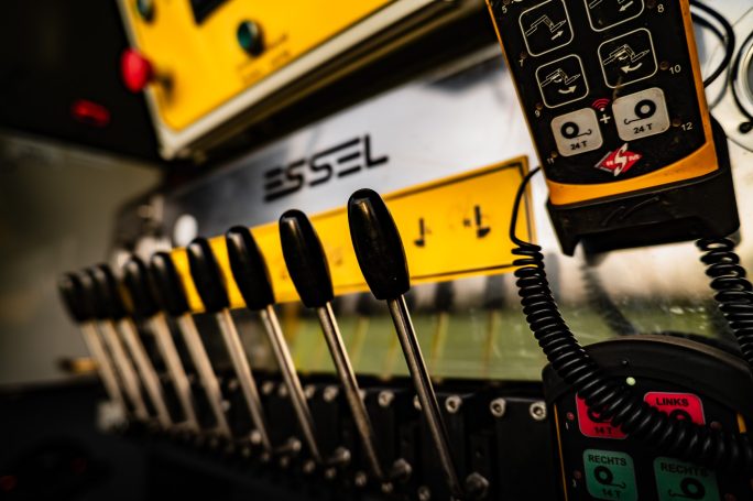 Steuerungspult mit Hebeln und Bedienelementen in gelb und schwarz.