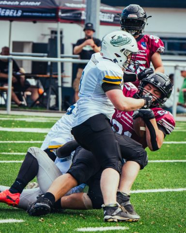Zwei Footballspieler kämpfen um den Ball auf dem Spielfeld.