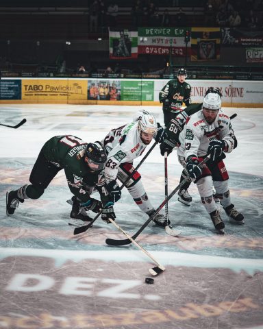 Eishockeyspiel: Spieler kämpfen um den Puck auf dem Eisfeld.
